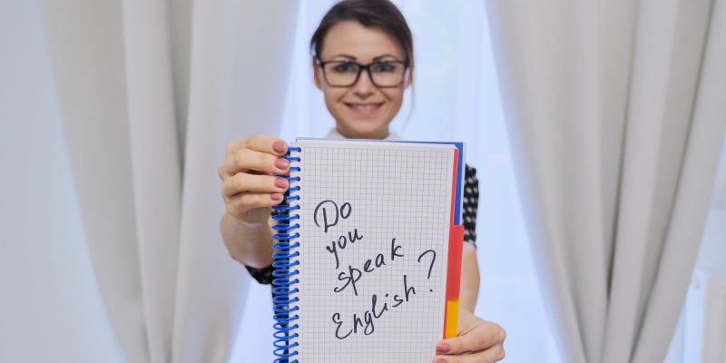 lektor angielskiego trzymająca kartkę z napisem czy mówisz po angielsku
